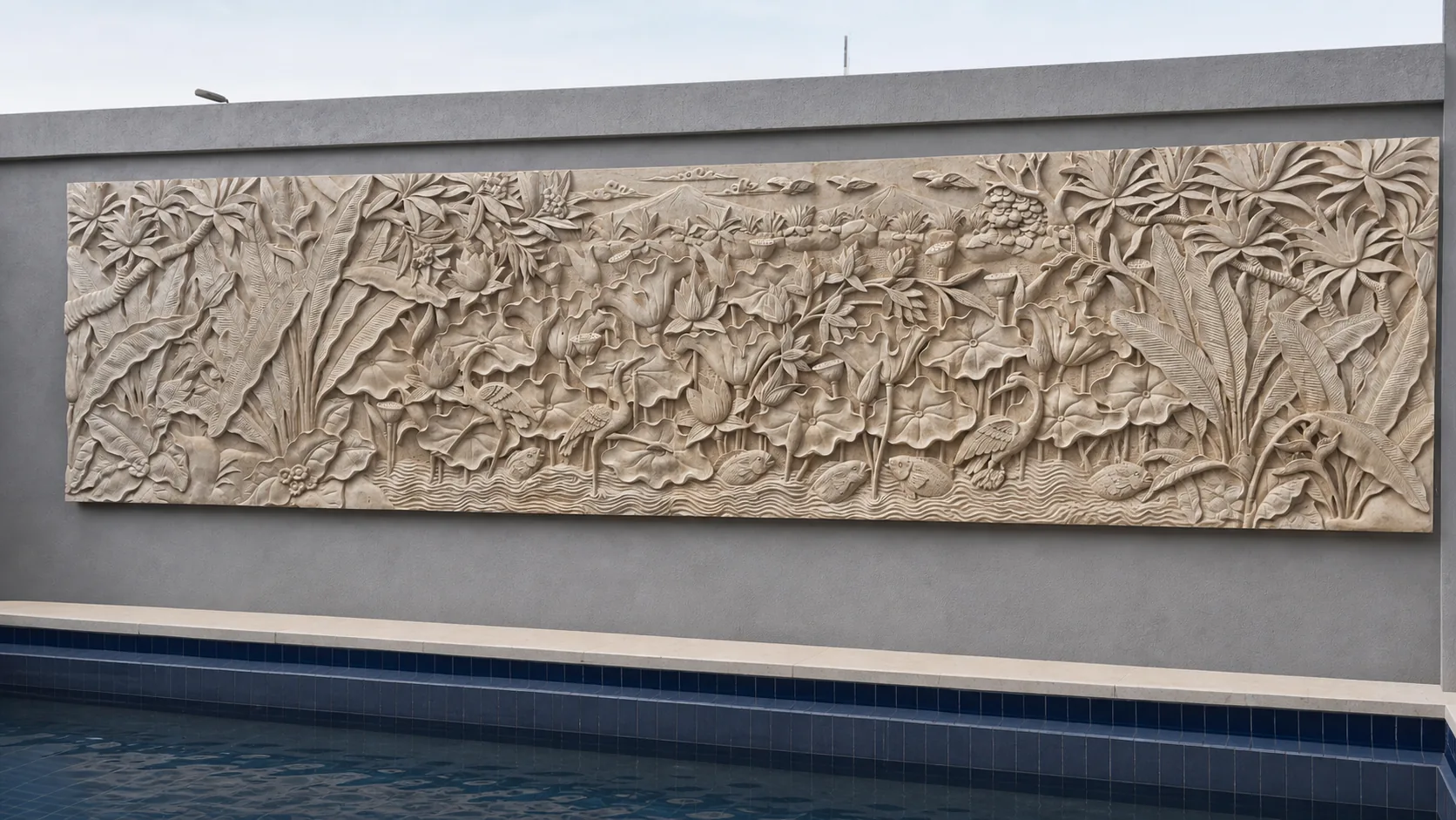 Long botanical stone relief above a poolside water feature